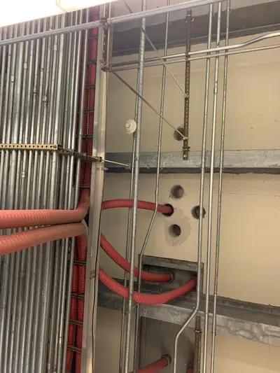 Rigid conduit stubbed up out of a concrete deck and racked to strut, bends set to a common radius and the ends capped off.