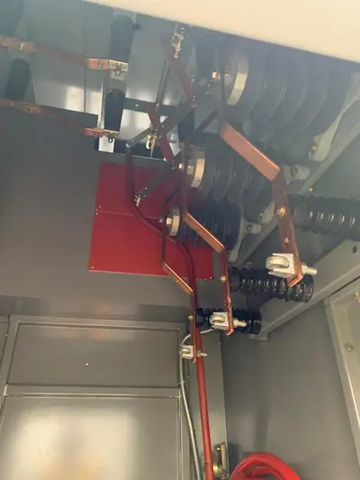 The blade contacts of a medium-voltage load-break switch, copper blades and moulded insulators carried on a common operating shaft.