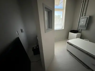 A finished room in the imaging suite with the branch panel on the wall beside the door and the ceiling closed in.